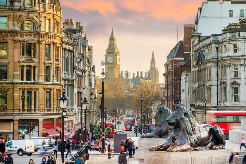 One of the bronze lions in Trafalgar Square, looking down Whitehall to Big Ben
